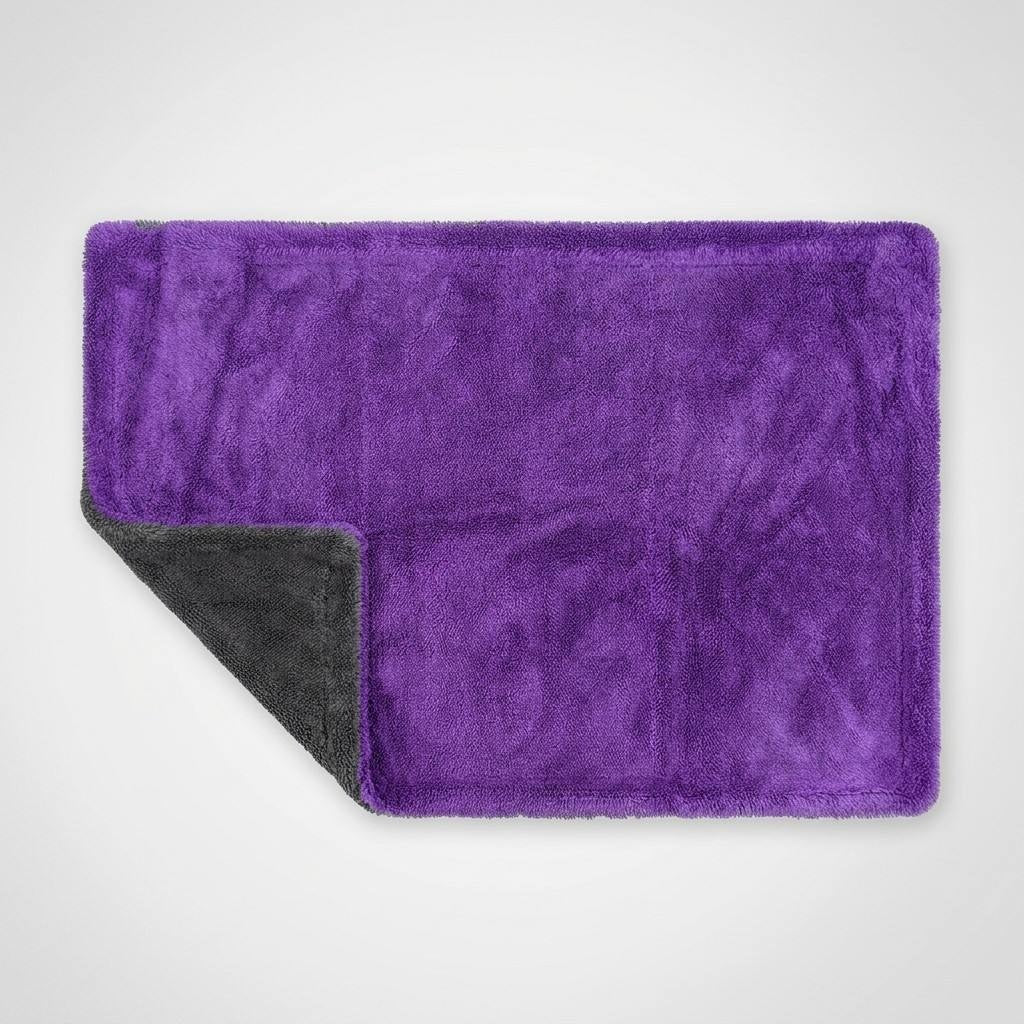 RB Innovations 1300GSM twisted loop microfibre drying towel laid flat, purple side up with the black corner folded back