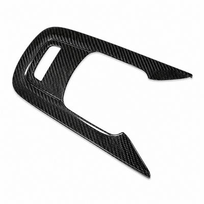 Toyota GR Corolla dry carbon fibre gear shift surround frame in gloss twill weave, angled studio view on white background